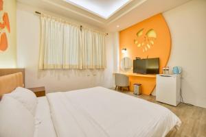 1 dormitorio con 1 cama, escritorio y TV en Easy Stay B&B, en Magong
