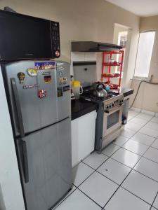 een keuken met een roestvrijstalen koelkast en een fornuis bij rodrich business apartment in Lima