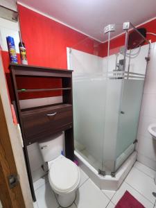 a bathroom with a toilet and a glass shower at rodrich business apartment in Lima