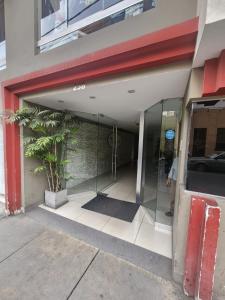 een toegang tot een gebouw met een glazen deur bij rodrich business apartment in Lima