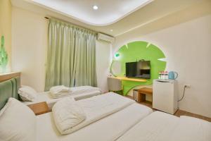 ein Hotelzimmer mit 2 Betten und einem TV in der Unterkunft Easy Stay B&B in Magong