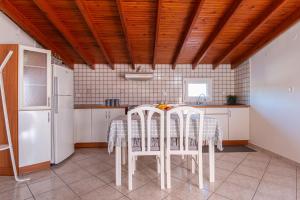 a kitchen with a table and chairs and a refrigerator at Sunset rooftop apartment in Thessaloniki