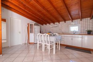 uma cozinha com uma mesa e cadeiras e um frigorífico em Sunset rooftop apartment em Tessalônica