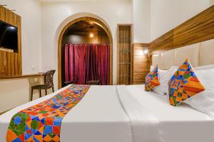 um quarto com uma grande cama branca num quarto em FabExpress Abad Inn em Mumbai