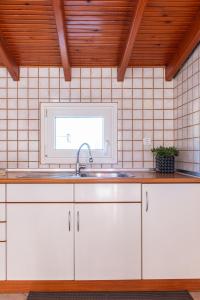 uma cozinha com armários brancos e um lavatório em Sunset rooftop apartment em Tessalônica