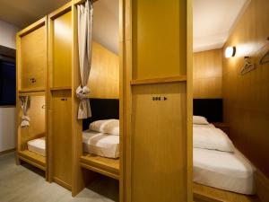 a small room with two beds and a closet at Hotel Plus Hostel TOKYO ASAKUSA 2 in Tokyo +11 photos