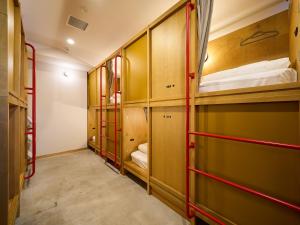 a room with wooden bunk beds and red rails at Hotel Plus Hostel TOKYO ASAKUSA 2 in Tokyo