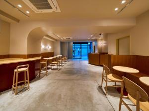 una fila di tavoli e sedie in una sala d'attesa di Hotel Plus Hostel TOKYO ASAKUSA 2 a Tokyo