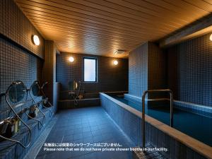 a bathroom with a sink and a bath tub at Hotel Plus Hostel TOKYO ASAKUSA 2 in Tokyo