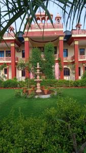 ein großes Gebäude mit einem Brunnen davor in der Unterkunft Hotel Pink Haveli in Jaipur