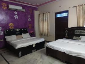 1 Schlafzimmer mit 2 Betten und einer lila Wand in der Unterkunft Hotel Pink Haveli in Jaipur