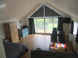 a living room with a couch and a large window at The Count House in Saint Hilary