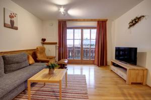 sala de estar con sofá y TV en Beim Bretzner - Chiemgau Karte, en Inzell