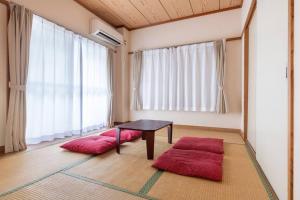 a room with a table and two red mats at Tokyo Skytree Residence Inn (F2) in Tokyo