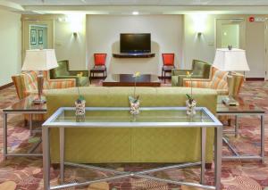 a lobby with a couch and tables and chairs at Holiday Inn Blytheville, an IHG Hotel in Blytheville
