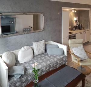 ein Wohnzimmer mit Sofa und eine Küche in der Unterkunft Deich in Karolinenkoog