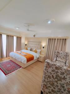um quarto grande com uma cama e uma cadeira em Sangaylay palace em Leh