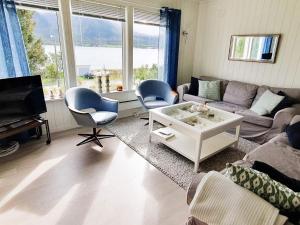 a living room with a couch and a table and chairs at Holiday home Svensby III in Svensby