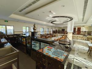 a restaurant with tables and chairs in a room at ALYA Hotel in Barka