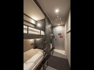 a small room with two bunk beds and a hallway at Hotel Plus Hostel TOKYO AKIHABARA in Tokyo