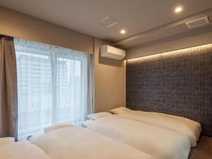 1 Schlafzimmer mit 2 Betten und einem Fenster in der Unterkunft Hotel Plus Hostel TOKYO AKIHABARA in Tokio