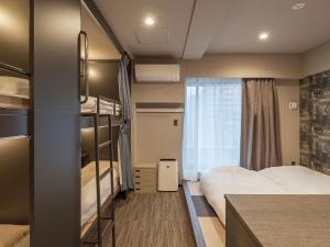 東京にあるホテルプラスホステル東京秋葉原のベッド2台と窓が備わるホテルルームです。