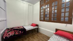 a small room with two beds and a window at Lakeland Homestay Diphu in Diphu