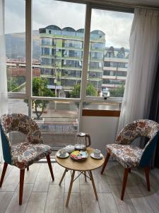 um quarto com duas cadeiras, uma mesa e uma janela em EL ALAMO, EJECUTIVO Y SPA em Cusco