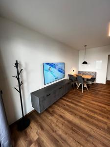un salon avec une grande télévision murale à écran plat dans l'établissement Mountain Home Alpendorf, à Plankenau