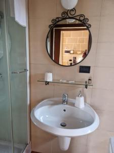 a bathroom with a sink and a mirror at Il Piccolo Rifugio in Castellana Grotte