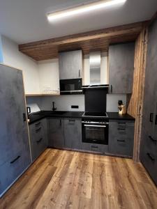 cocina grande con electrodomésticos de acero inoxidable y suelo de madera en Mountain Home Alpendorf, en Plankenau
