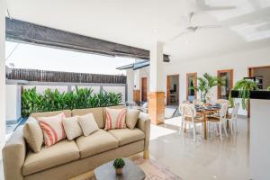 uma sala de estar com um sofá e uma mesa em Villa Arya - Canggu em Canggu