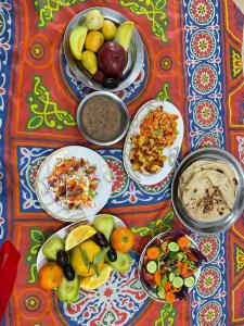 stół z talerzami jedzenia i miskami z wodą w obiekcie ali habou w mieście Luksor