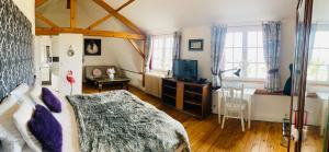 a bedroom with a bed and a tv in it at LOGIS HOTEL BELLEVUE RESTAURANT LA POMME d'OR in Coucy-le-Château-Auffrique +97 photos