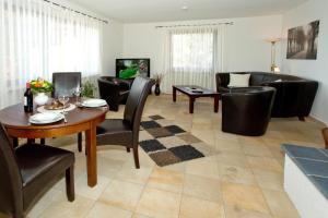 a living room with a table and chairs and a couch at NEU! Ferienwohnung Zum Kaminzimmer in Toppenstedt