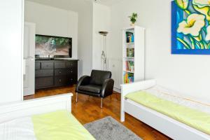 a bedroom with a bed and a chair and a television at NEU! Ferienwohnung Zum Kaminzimmer in Toppenstedt