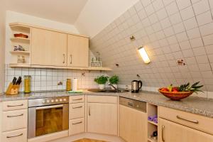 a kitchen with white cabinets and a bowl of fruit on the counter at NEU! Ferienwohnung zum Wiesenblick in Toppenstedt