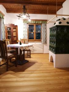 a living room with a table and a green cabinet at Ferienhaus Brunneben Häusl in Sankt Margarethen im Lungau