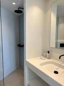 Un baño blanco con lavabo y espejo. en Vivant Naousa Residence 2, en Naousa 8 fotos más