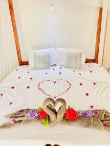 a bed with a heart made out of flowers at Dilena Beach Inn in Tangalle