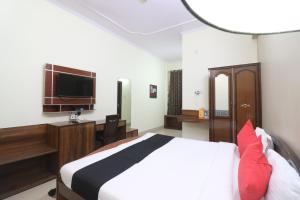 a bedroom with a bed and a desk and a tv at Hotel Mandakini in Rudraprayāg