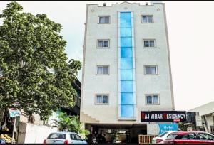 ein hohes Gebäude mit davor geparkt in der Unterkunft Hotel Raj vihar residency in Vijayawāda