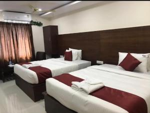 2 Betten in einem Hotelzimmer mit 2 Betten sidx sidx sidx sidx in der Unterkunft Hotel Raj vihar residency in Vijayawāda