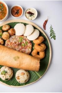 um prato de alimentos com carne e batatas e outros alimentos em Hotel Raj vihar residency em Vijayawada