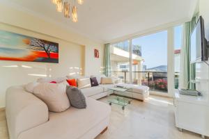 a living room with a white couch and a large window at Skyler Villaları in Kas