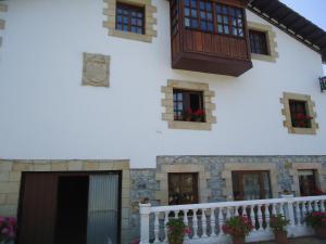 un edificio bianco con finestre e balcone di Montañes a Santillana del Mar