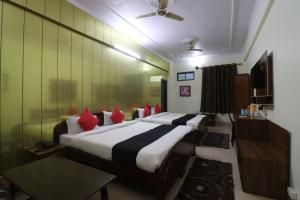 a hotel room with two beds with red pillows at Hotel Mandakini in Rudraprayāg