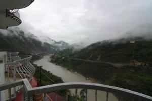 Una vista de un río con montañas al fondo. en Hotel Mandakini, en Rudraprayāg