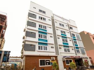 um edifício branco com janelas azuis numa rua em Capital O Sri Navya Grand Near Nexus Hyderabad em Lingampalli