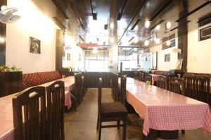a dining room with tables and chairs in a restaurant at Hotel Mandakini in Rudraprayāg